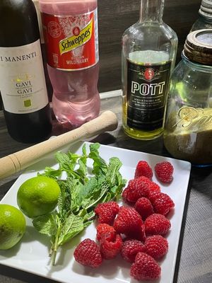 Cocktailzutaten für die Online-Party: Weißwein, Schweppes Waldbeere, Pott Rum. brauner Zucker, Limetten, frische Minze, Himbeeren und ein Holzstössel